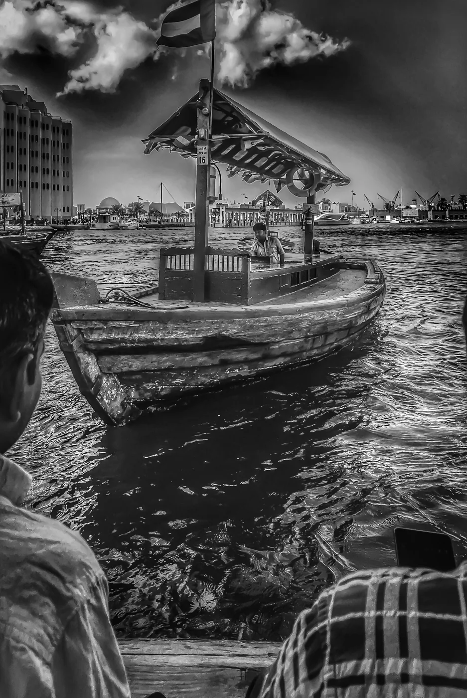 An abra wooden passenger boat on Dubai Creek in black and white