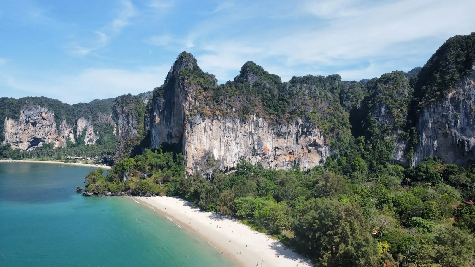 Railay Beach beneath limestone cliffs and tropical forest in Krabi