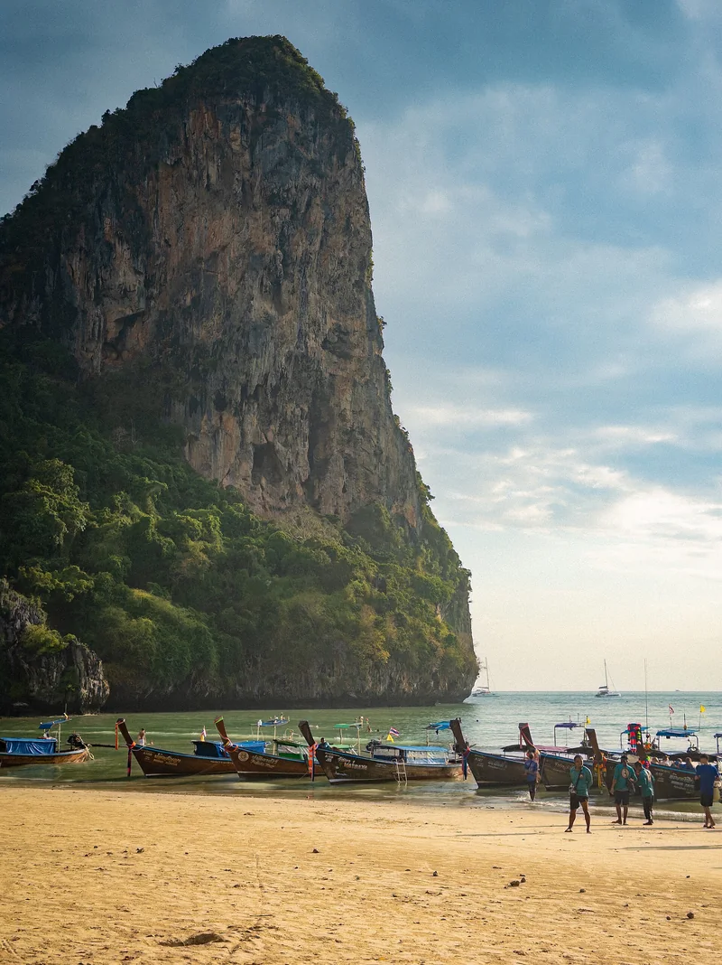 A limestone cliff above longtail boats on Railay West Beach